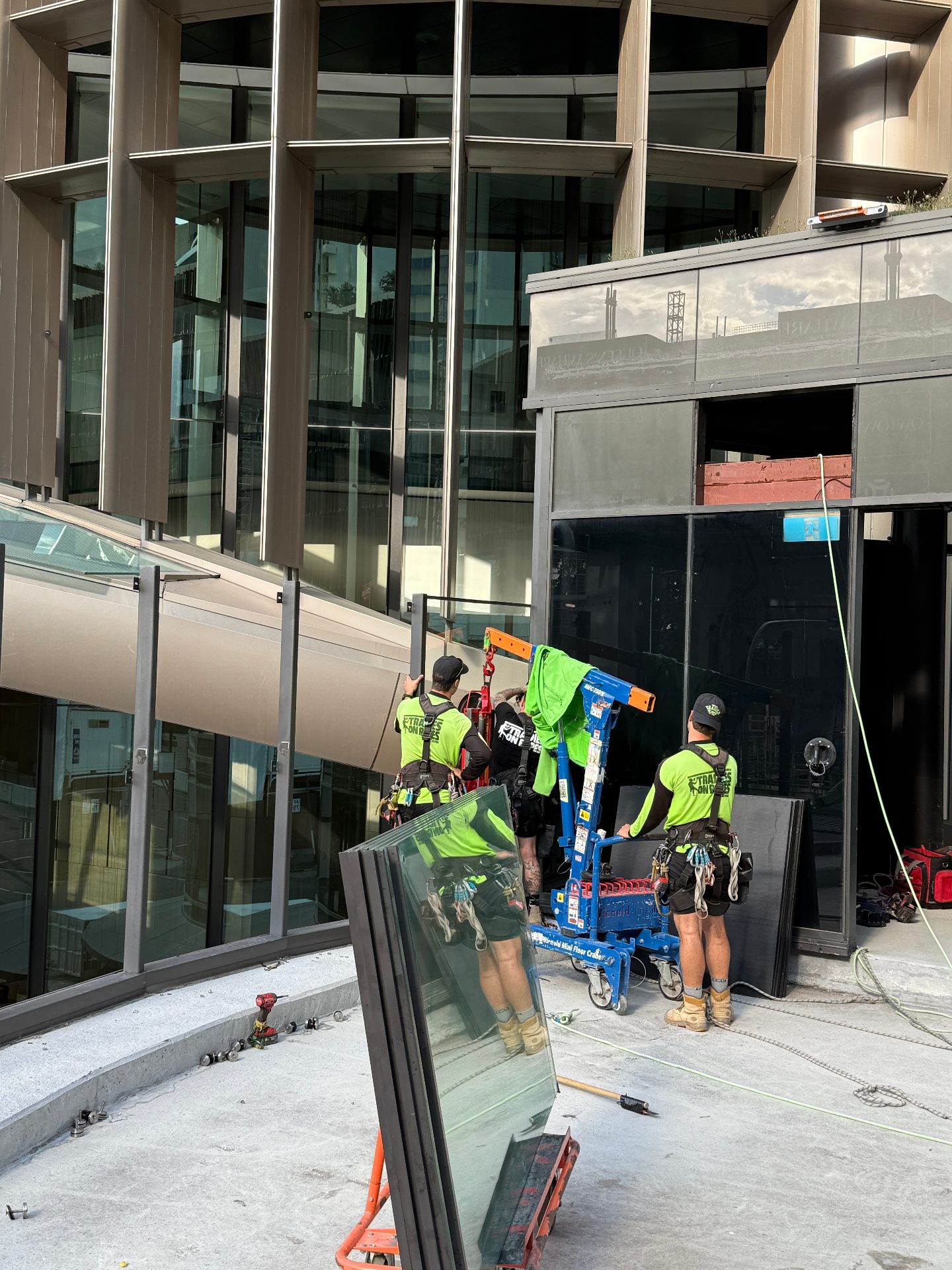 Tradies on Ropes glaziers loading glass onto a Wienold mini floor crane at 1 William Street Brisbane
