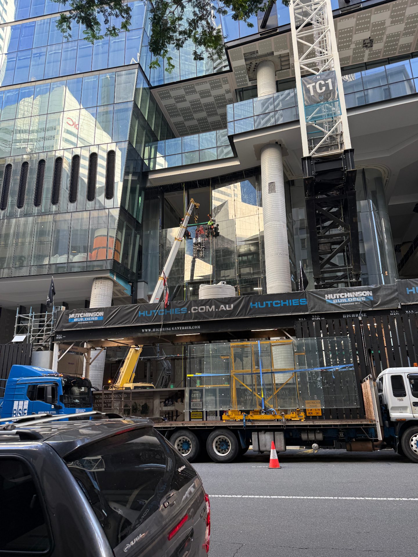 Street view of 360 Queen Street Brisbane with glass panel being craned into the façade