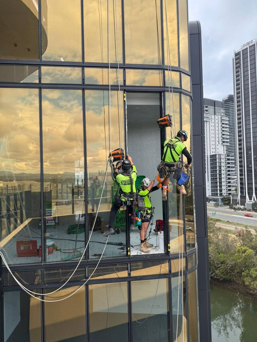 Tradies on Ropes technicians performing glazing work on a high-rise building façade using rope access
